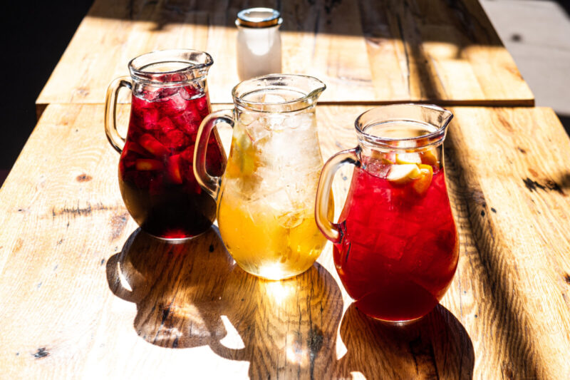 Three pitchers of sangria at a Cafe Ba-Ba-Reeba! dining table used as a decorative photo for Pride Month