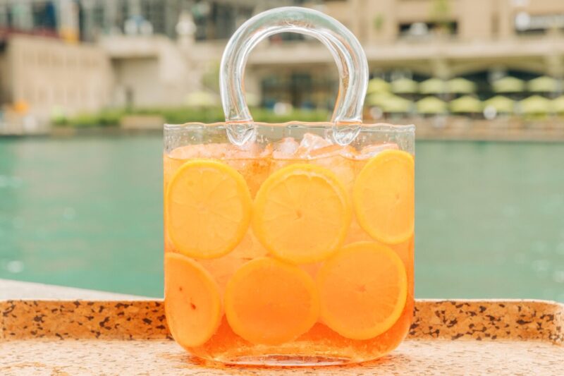Cocktail in a large, clear, glass purse