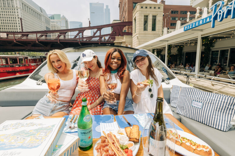 Four women enjoying Pizzeria Portofino's boat menu on a yacht.